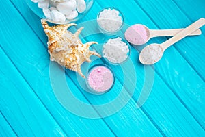 Sea Ã¢â¬â¹Ã¢â¬â¹salt in a glass white stones and Shell for spa and relaxation on a blue background